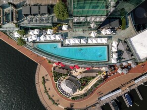 An aerial view of a resort with a large swimming pool, sun loungers, and outdoor seating areas. - Four Seasons Hotel Baltimore (Baltimore)