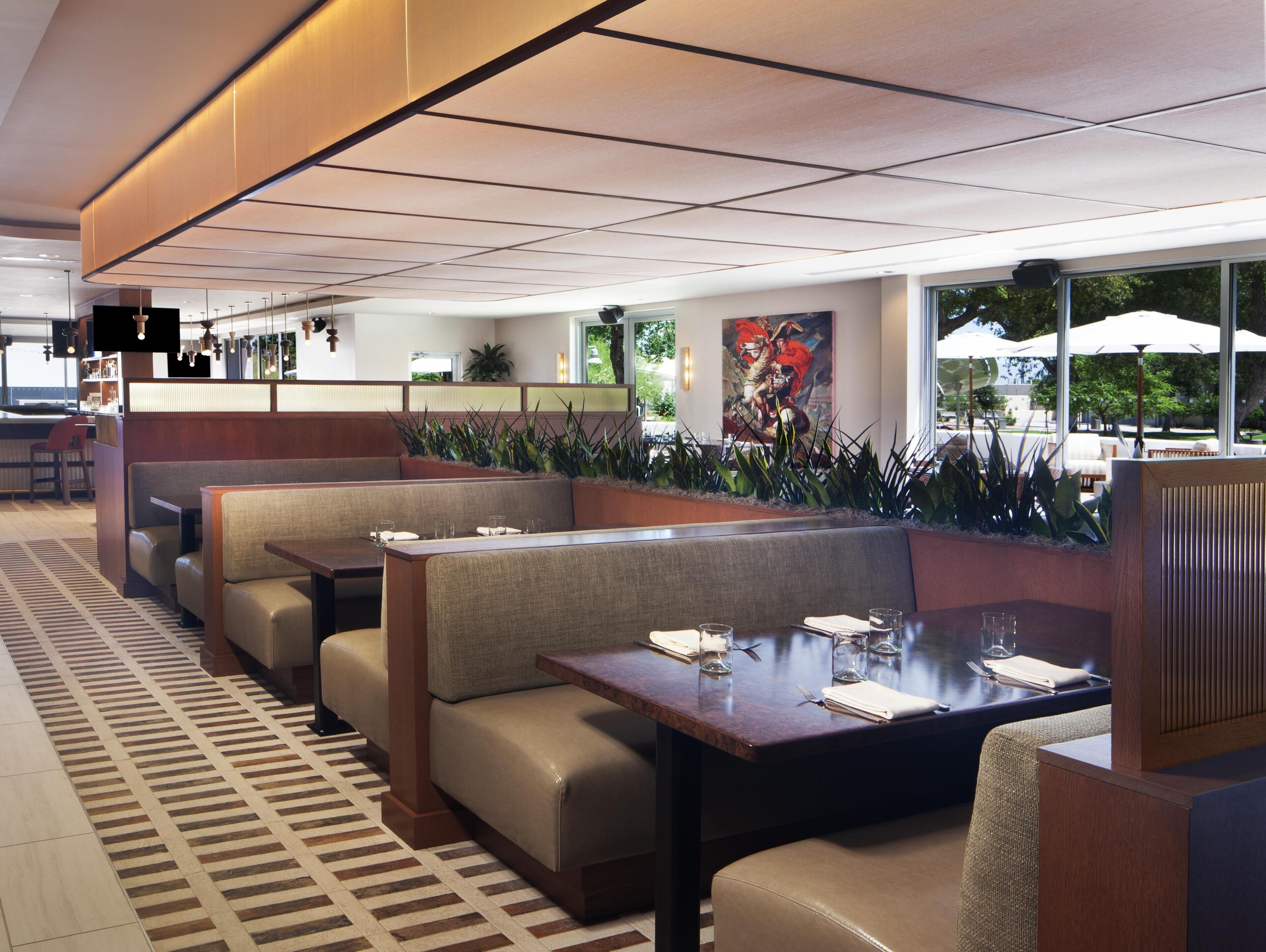 A restaurant with booth seating, a patterned floor, and a view of the outdoors.