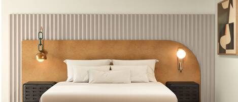A modern bedroom with a headboard, a bed with white bedding, two bedside tables, and a patterned rug.