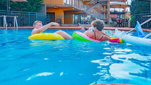 Piscina com pessoas usando boias.