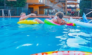 Una piscina al aire libre, sillones reclinables de piscina
