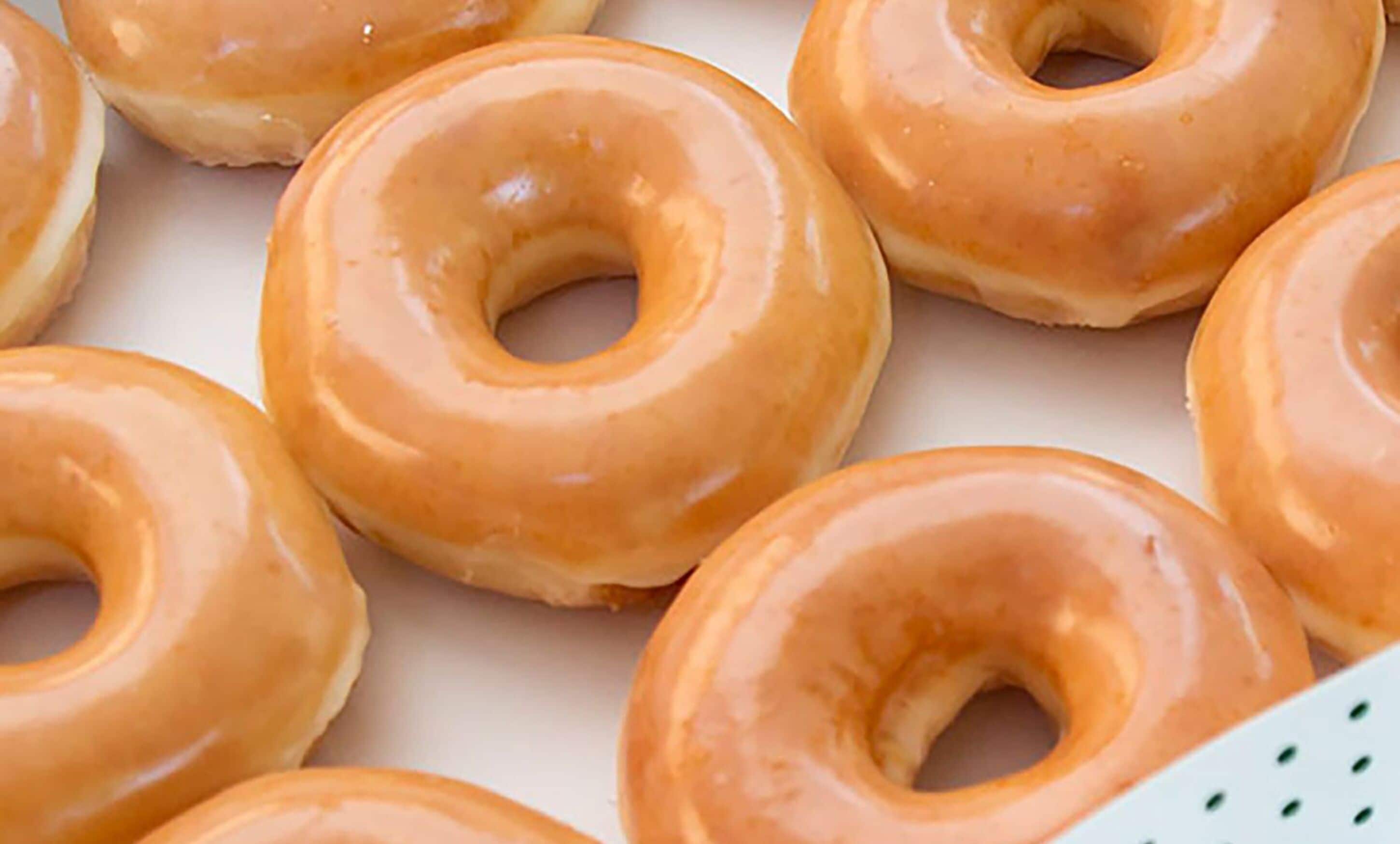 A close-up of glazed donuts arranged on a surface.
