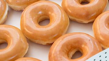 A close-up of glazed donuts arranged on a surface.
