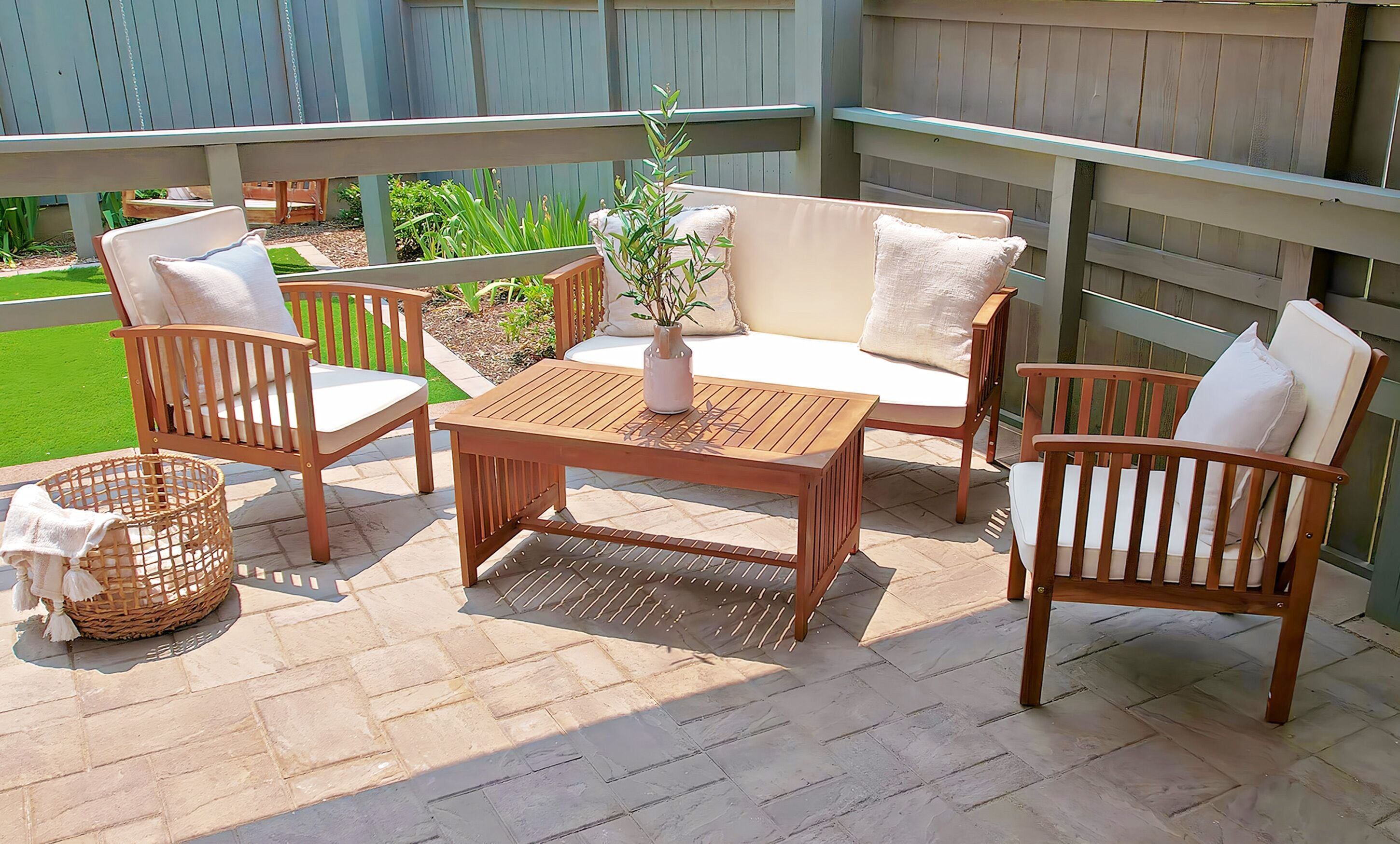 A patio with wooden furniture, including a sofa, chairs, and a table.