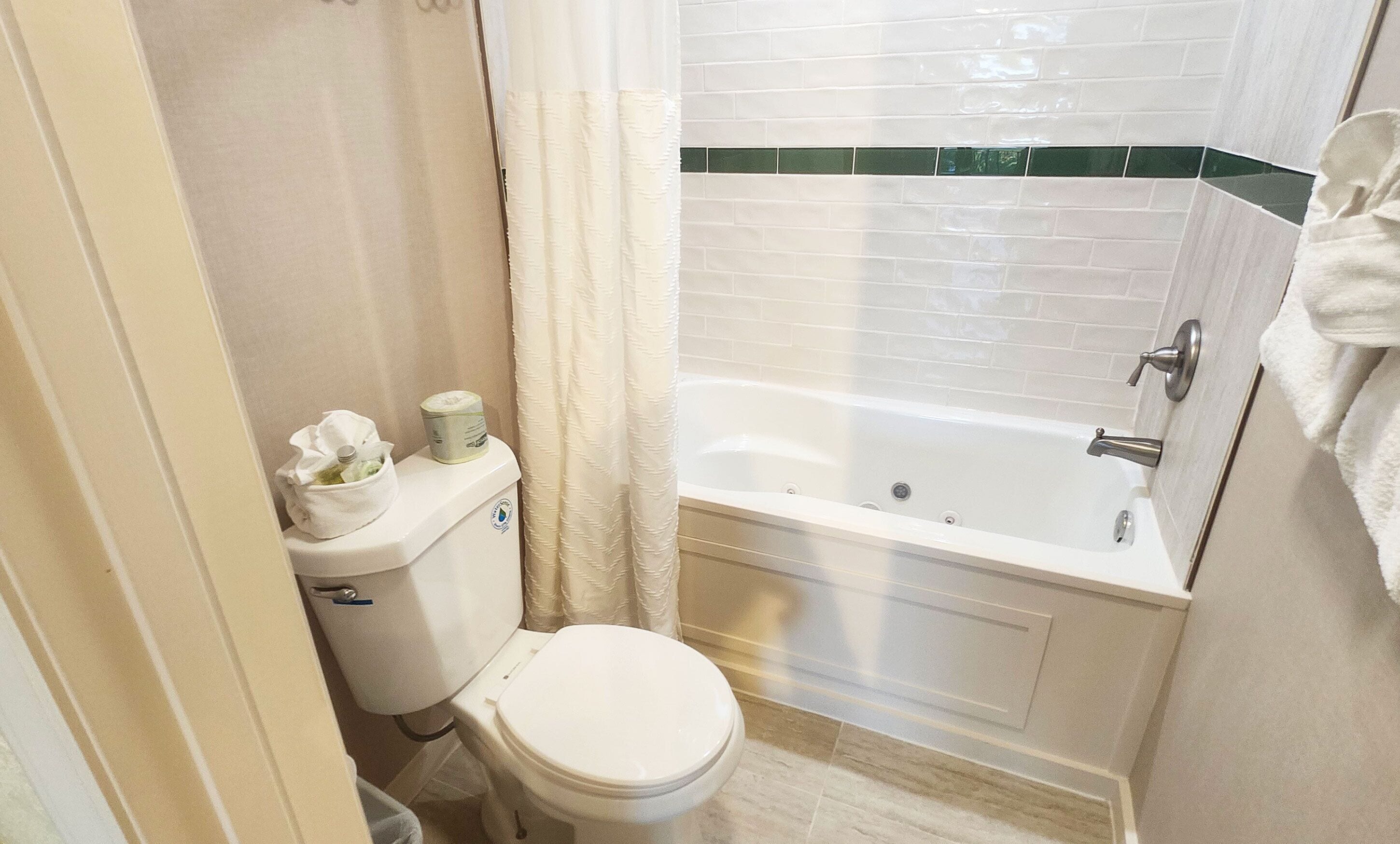 A bathroom with a toilet, a bathtub, and a shower curtain.