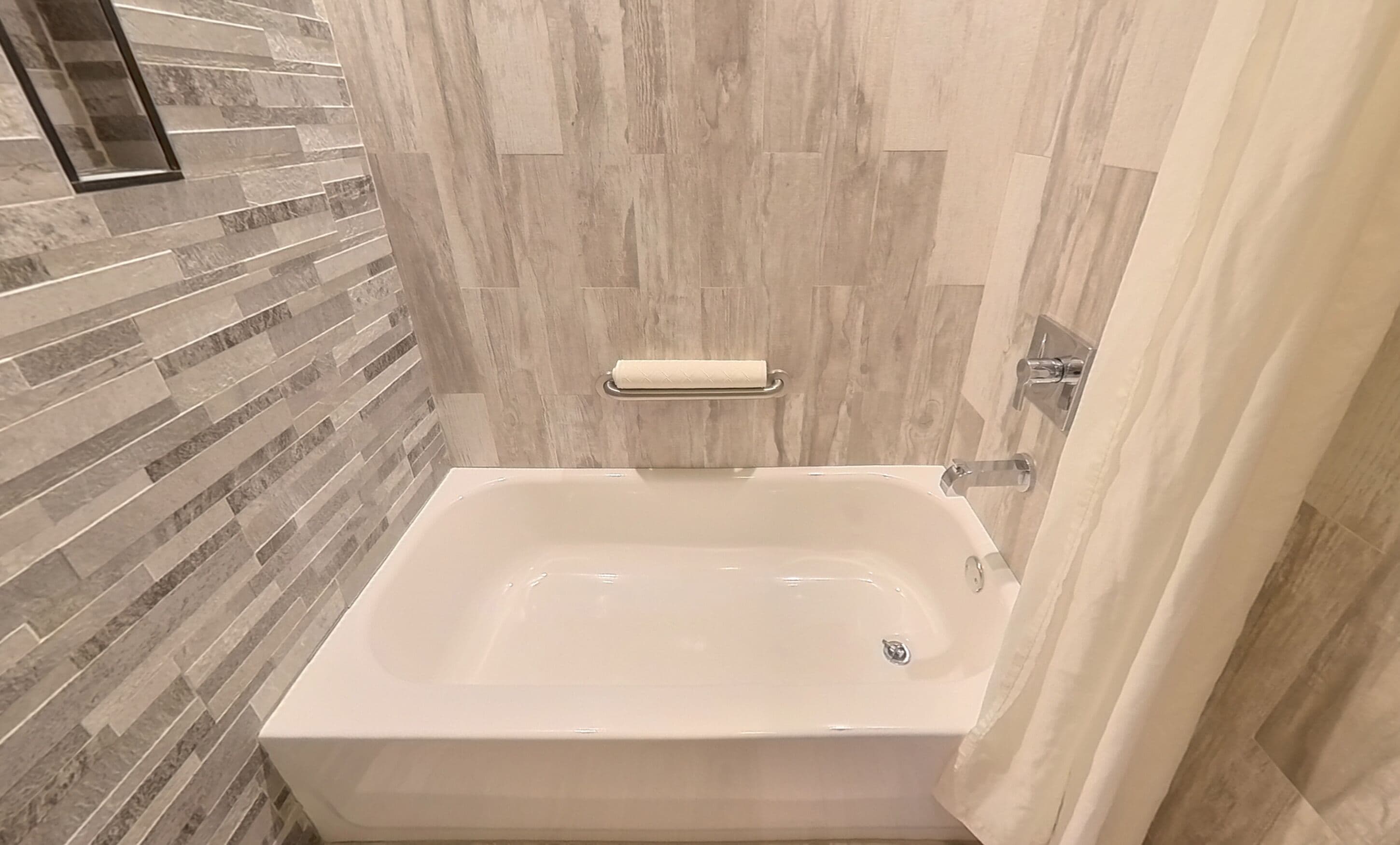 A modern bathroom with a freestanding bathtub, a towel rack, and a shower curtain.