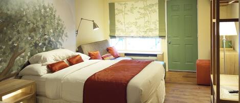 A bedroom with a bed, nightstands, a window with a view, and a green door.