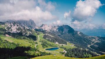 Un paysage montagneux avec un lac, des routes et des zones boisées.