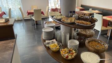 Una mesa de buffet con diversos alimentos y utensilios para servir.