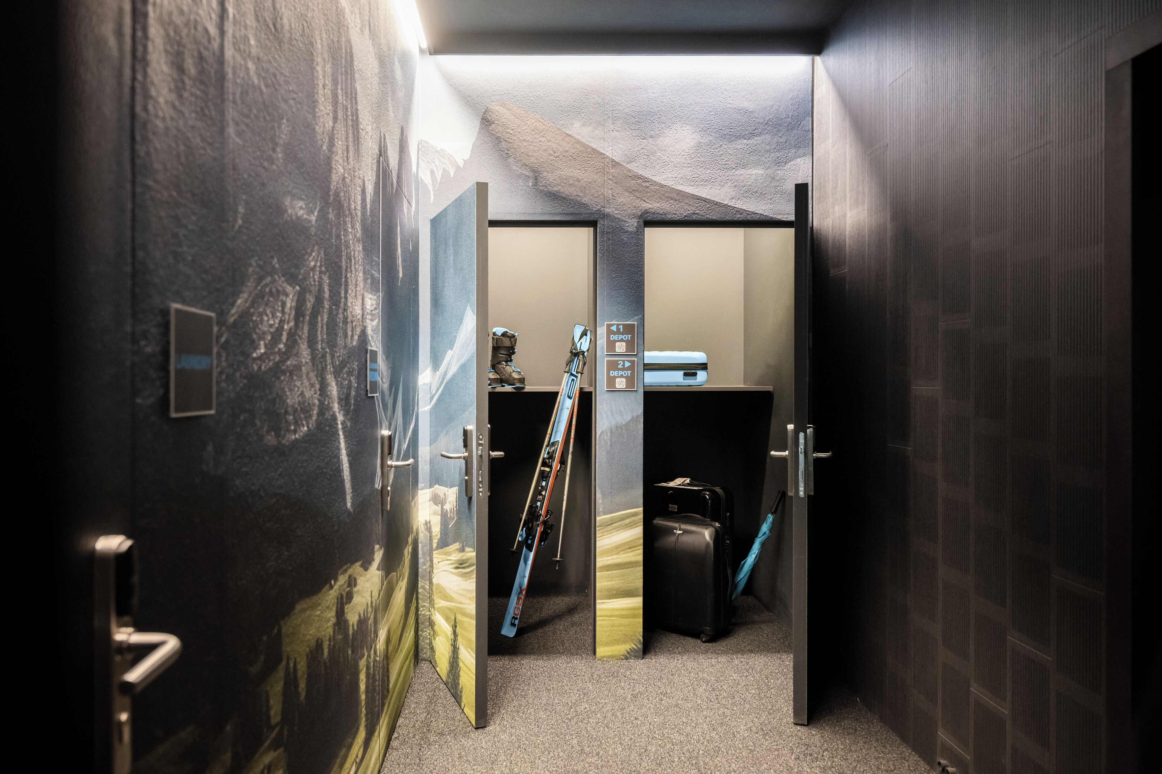 A hallway with a ski rack, a suitcase, and a wall with a mountain landscape mural.
