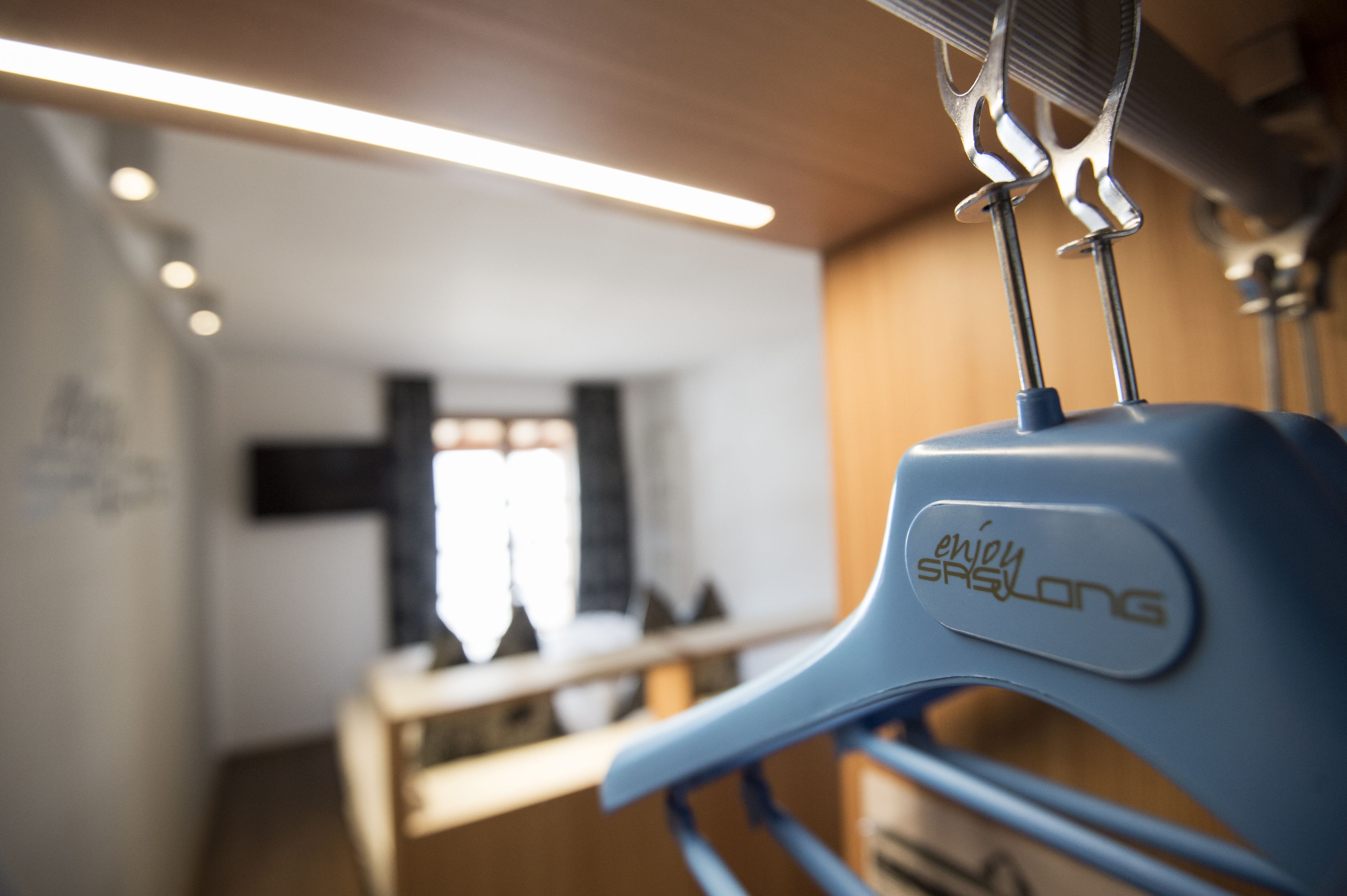 Una habitación con una cama, un ventanal y un radiador fijado a la pared.