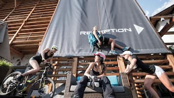 A group of people on a wooden deck with a large banner reading "RECEPTION" in the background.