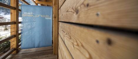 A wooden staircase leading to a room with a sign reading "SASLONG EU hotel".