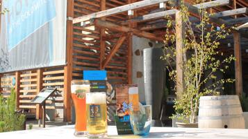 A wooden structure with a sign for a hotel, a table with glasses of beer, and a barrel.