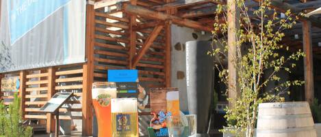 A wooden structure with a sign for a hotel, a table with glasses of beer, and a barrel.