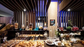 Un buffet proposant une variété de pâtisseries, de desserts et de boissons.