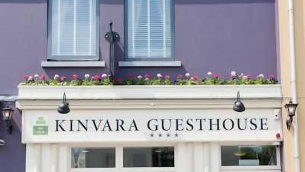 The exterior of the Kinvara Guesthouse, featuring a white facade, a balcony with flowers, and a clear entrance. - Kinvara Guesthouse (Kinvara)