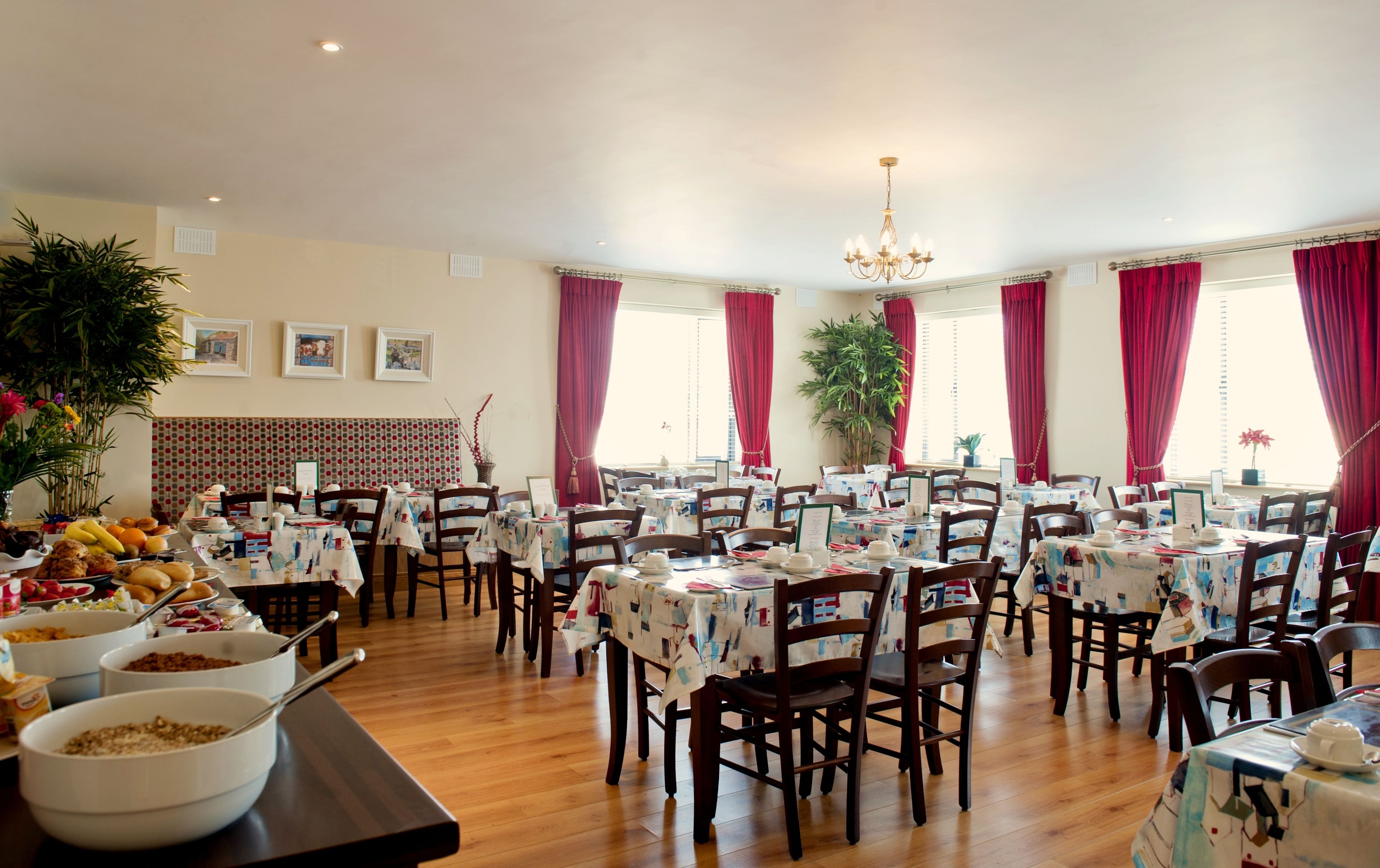 A dining area with multiple tables, chairs, and a variety of food items on display.