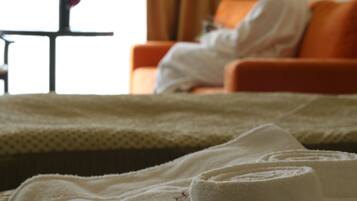 Una habitación de hotel con una cama, una silla y una mesa con un objeto rojo encima.