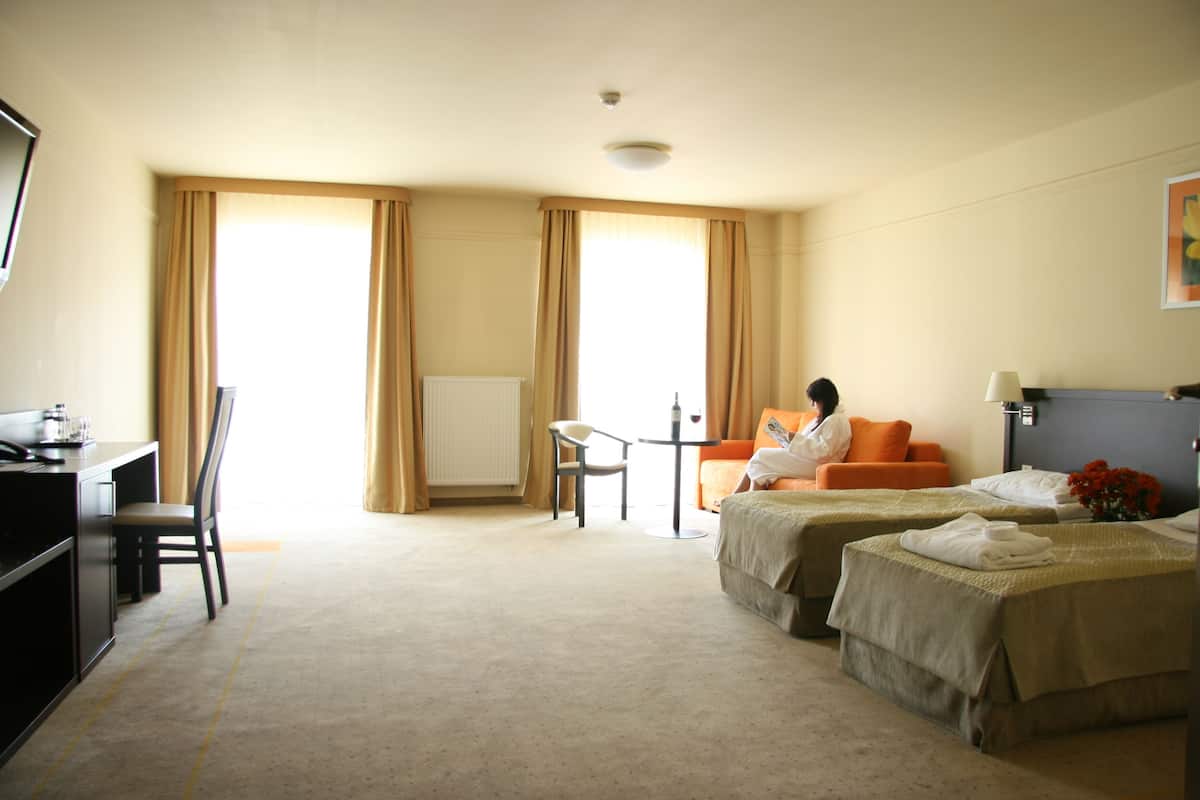 Una habitación de hotel con dos camas, un escritorio, una silla y una mesa.