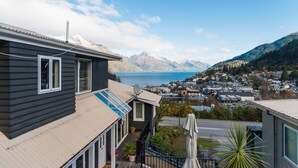 A residential building with a balcony, a satellite dish, and a view of a town and mountains in the distance. - Queenstown House (Queenstown)