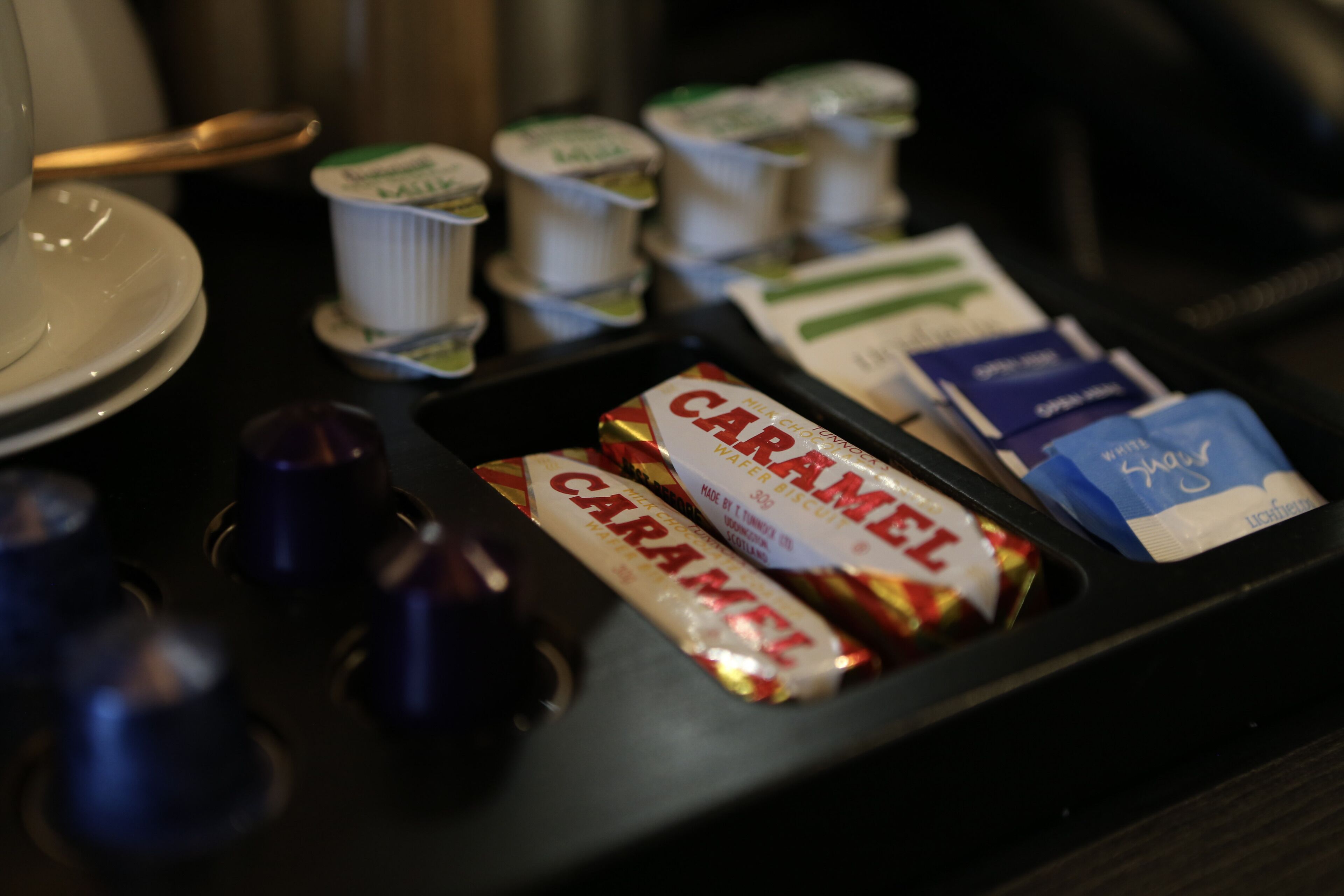 A tray with food items including caramel and a package of what appears to be a snack or dessert.