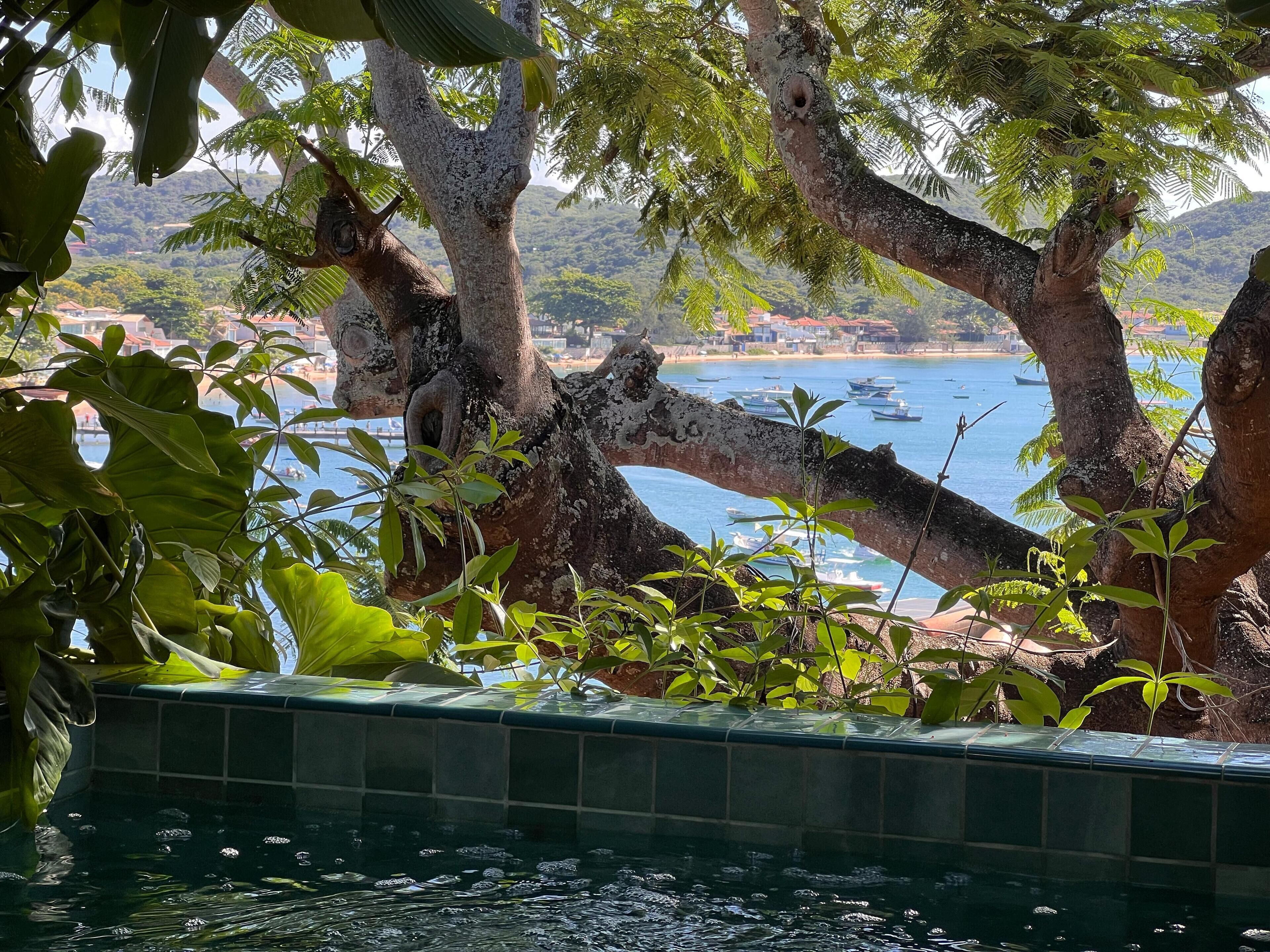 Zona piscina con vista su barche su un lago e un paesaggio montano sullo sfondo.