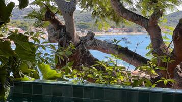 Zona piscina con vista su barche su un lago e un paesaggio montano sullo sfondo.