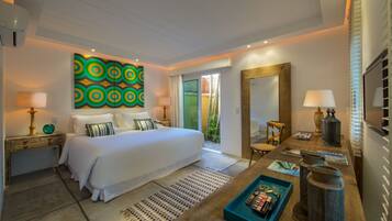 A modern hotel room with a large bed, a wooden nightstand, a desk with a lamp, a mirror, and a colorful abstract painting on the wall.