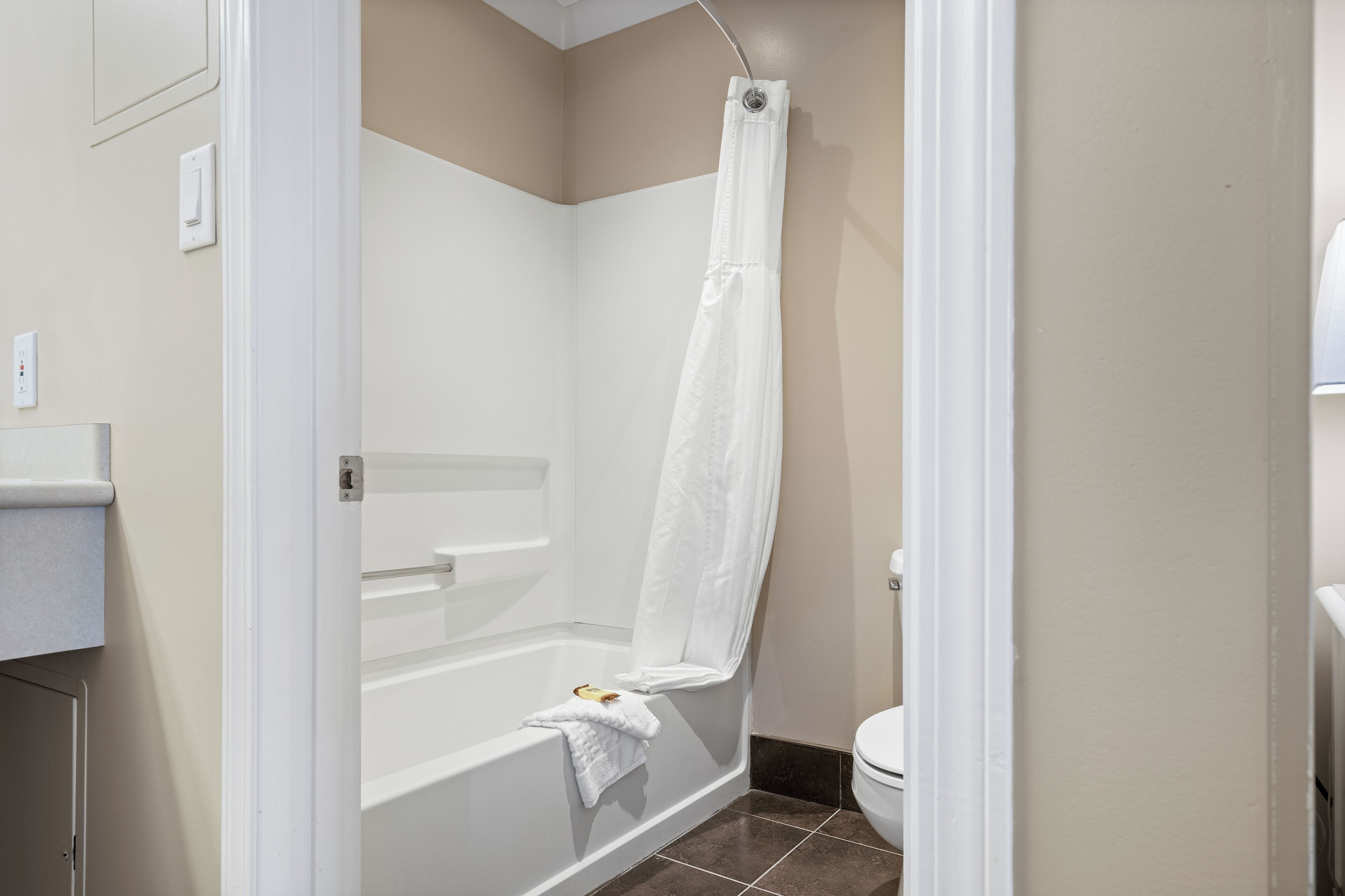 A bathroom with a bathtub, toilet, and a shower curtain.