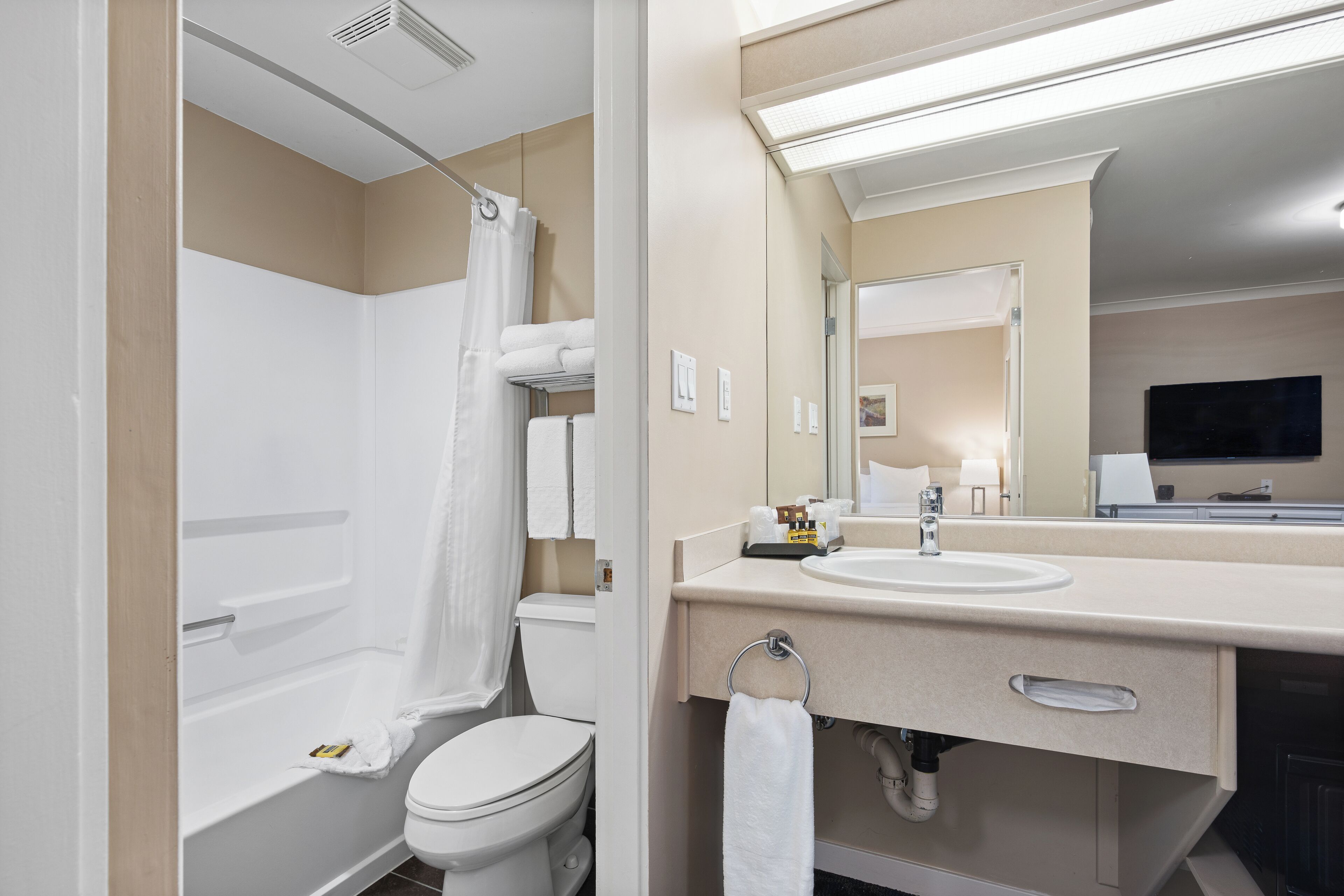 A modern bathroom with a bathtub, toilet, and sink.