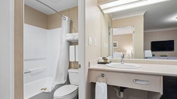 A modern bathroom with a bathtub, toilet, and sink.