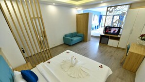 Une chambre d’hôtel avec un lit, un canapé, une télévision et une cloison en bois.
