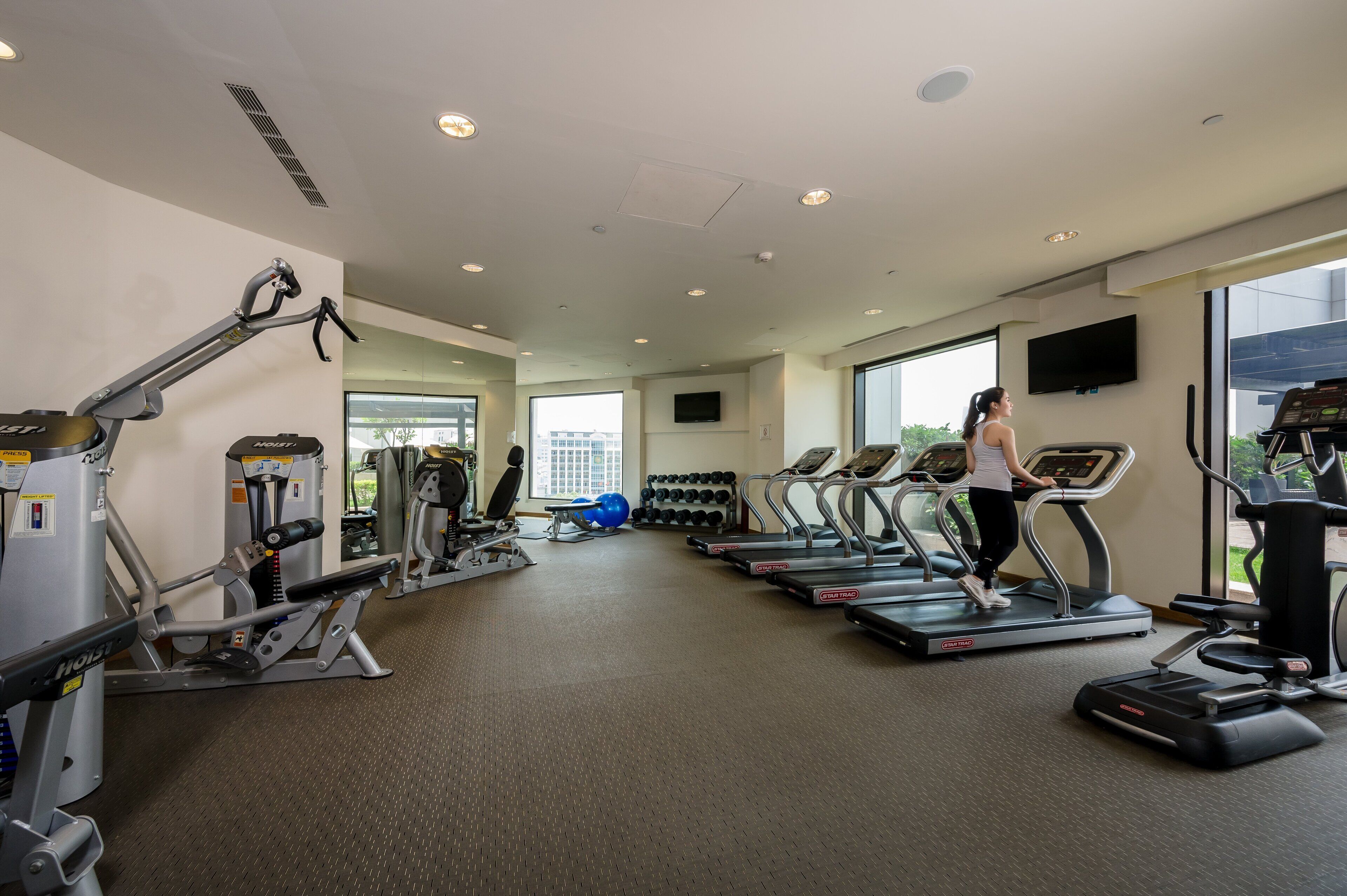 A gym with treadmills, weight machines, and exercise balls.