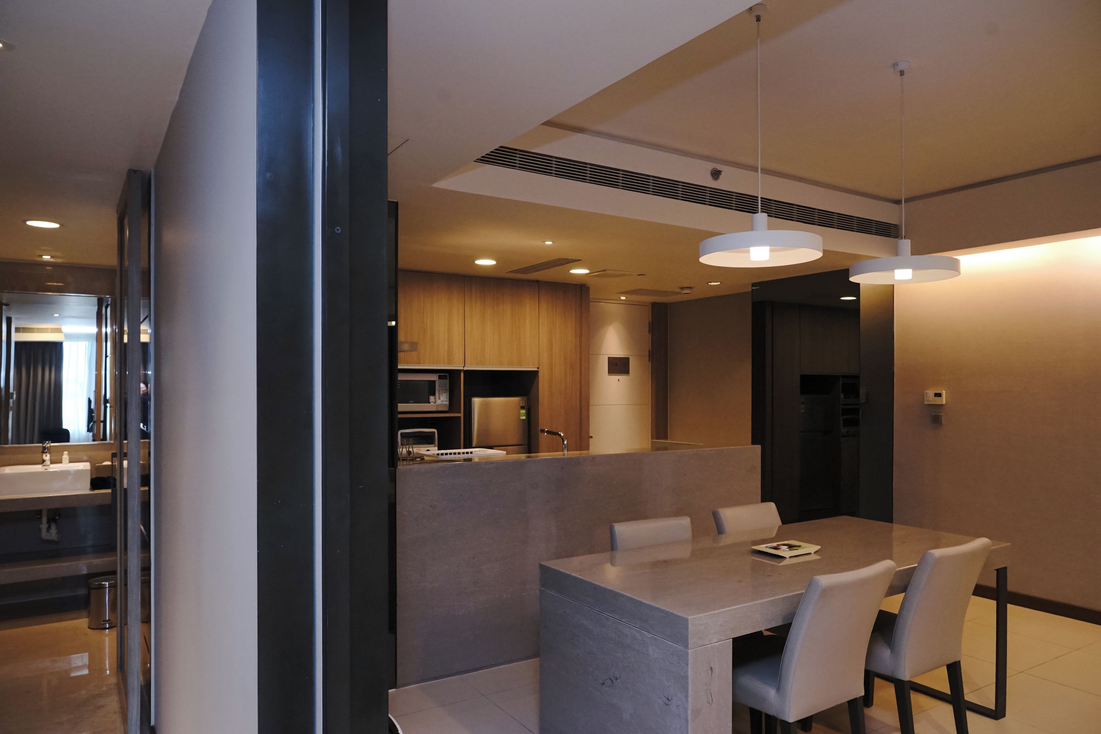 A modern kitchen with built-in appliances and a dining area with a table and chairs.