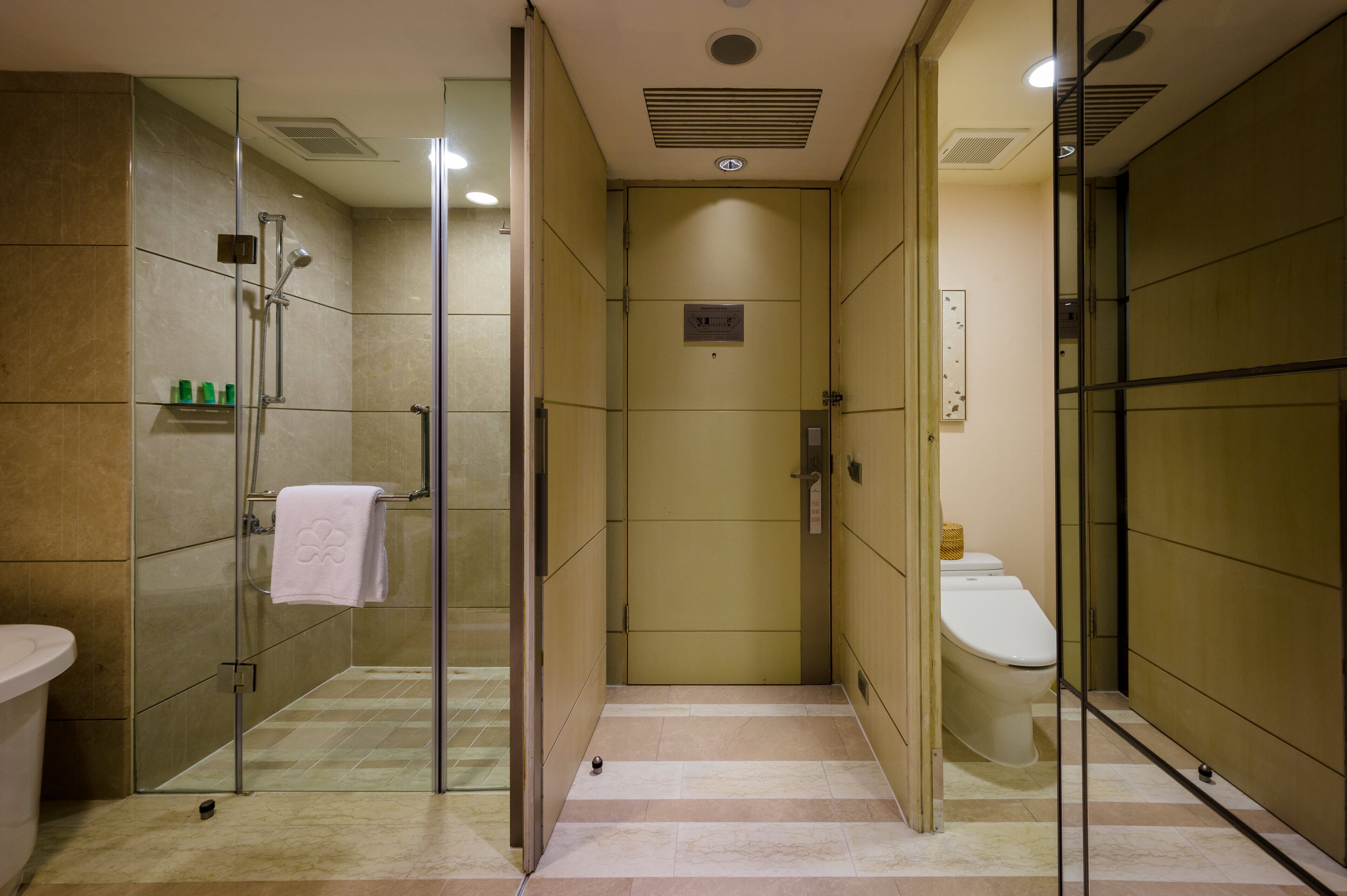 A modern bathroom with a glass-enclosed shower, a toilet, and a sink.