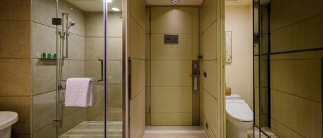 Une salle de bain moderne avec une douche à parois de verre, des toilettes et un lavabo.
