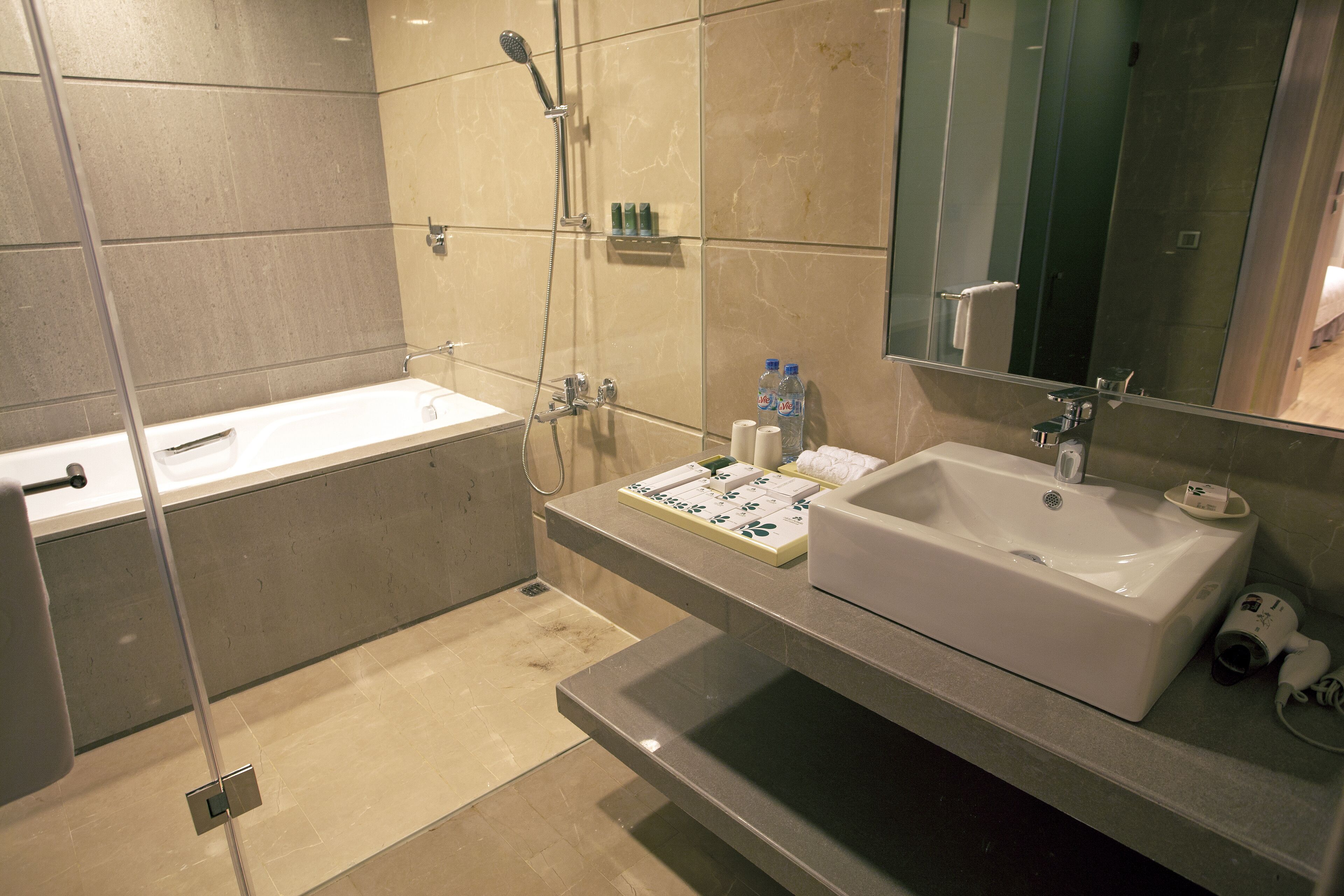 A modern bathroom with a bathtub, a sink, and a shower.