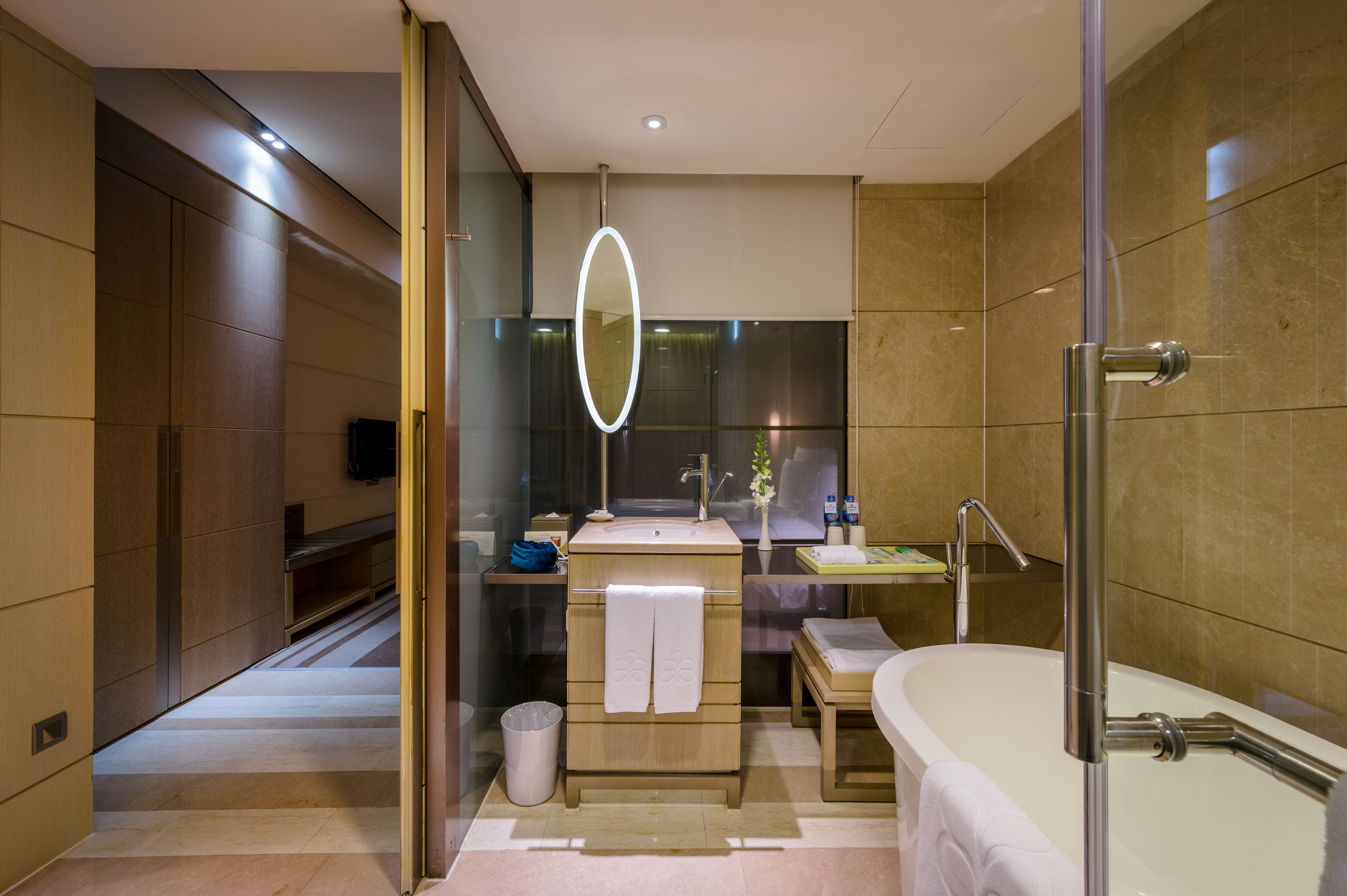 Un baño moderno con un espejo grande, una bañera, un lavabo y un mueble de tocador.
