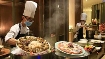 Chefs preparing seafood dishes in a professional kitchen with stainless steel equipment and a modern design.