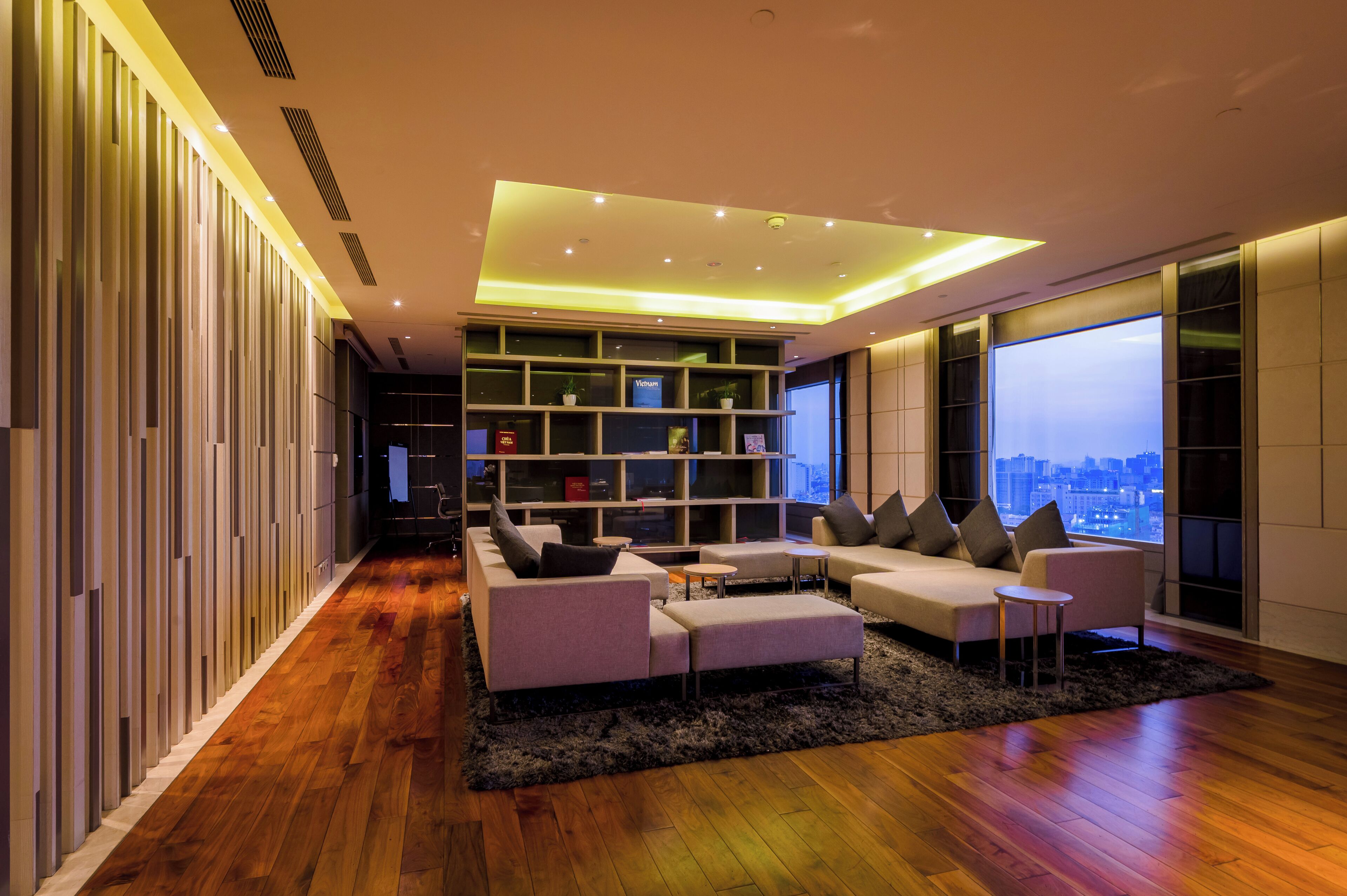 A modern living room with a sofa set, a coffee table, and a bookshelf.