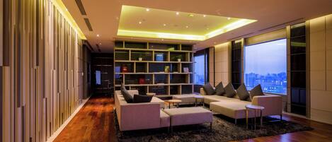 A modern living room with a sofa set, a coffee table, and a bookshelf.