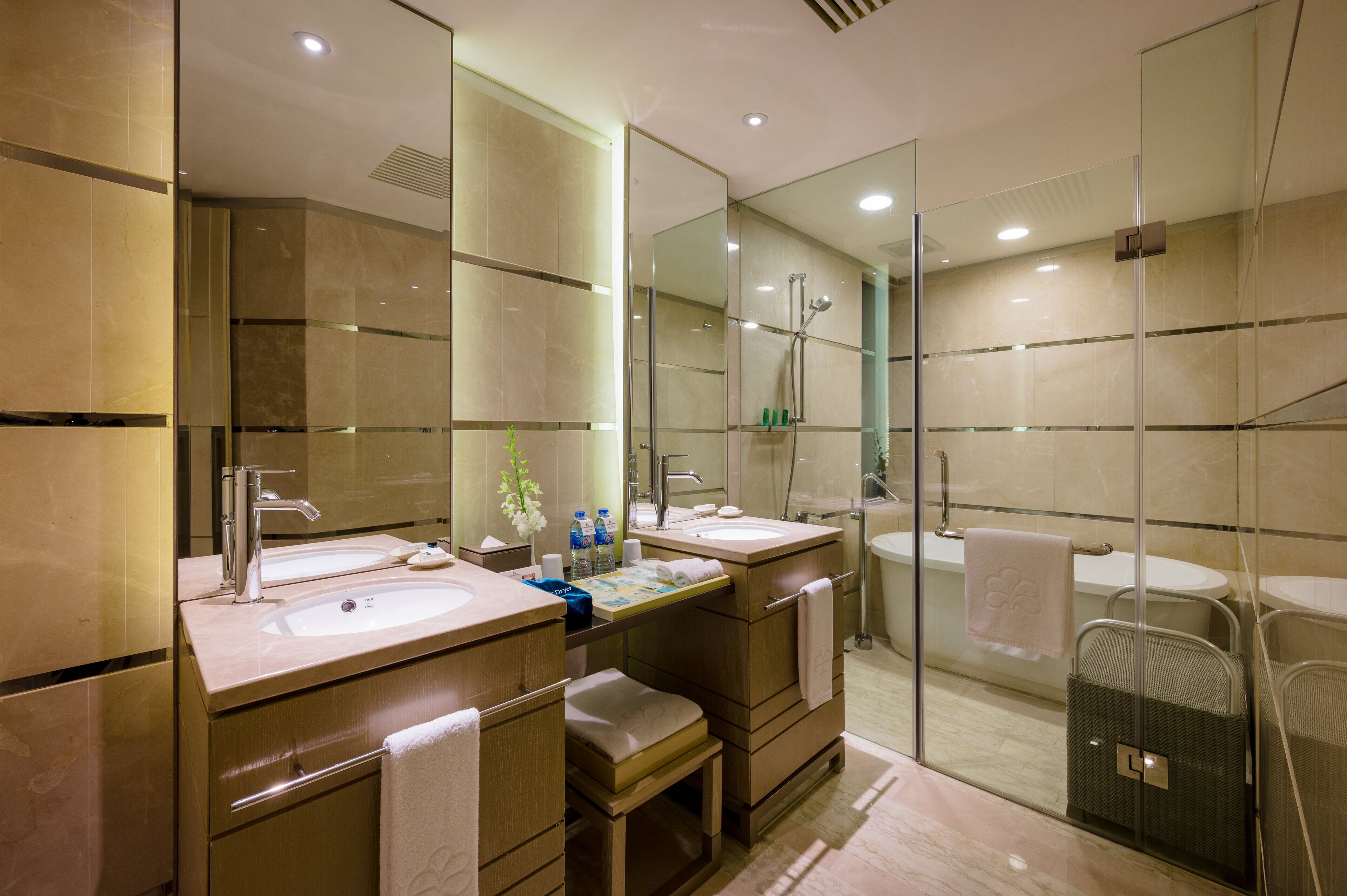A modern bathroom with two sinks, a shower, and a glass-enclosed shower area.