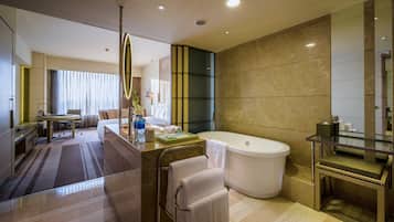 A modern bathroom with a large bathtub, a vanity with a mirror, and a shower area.