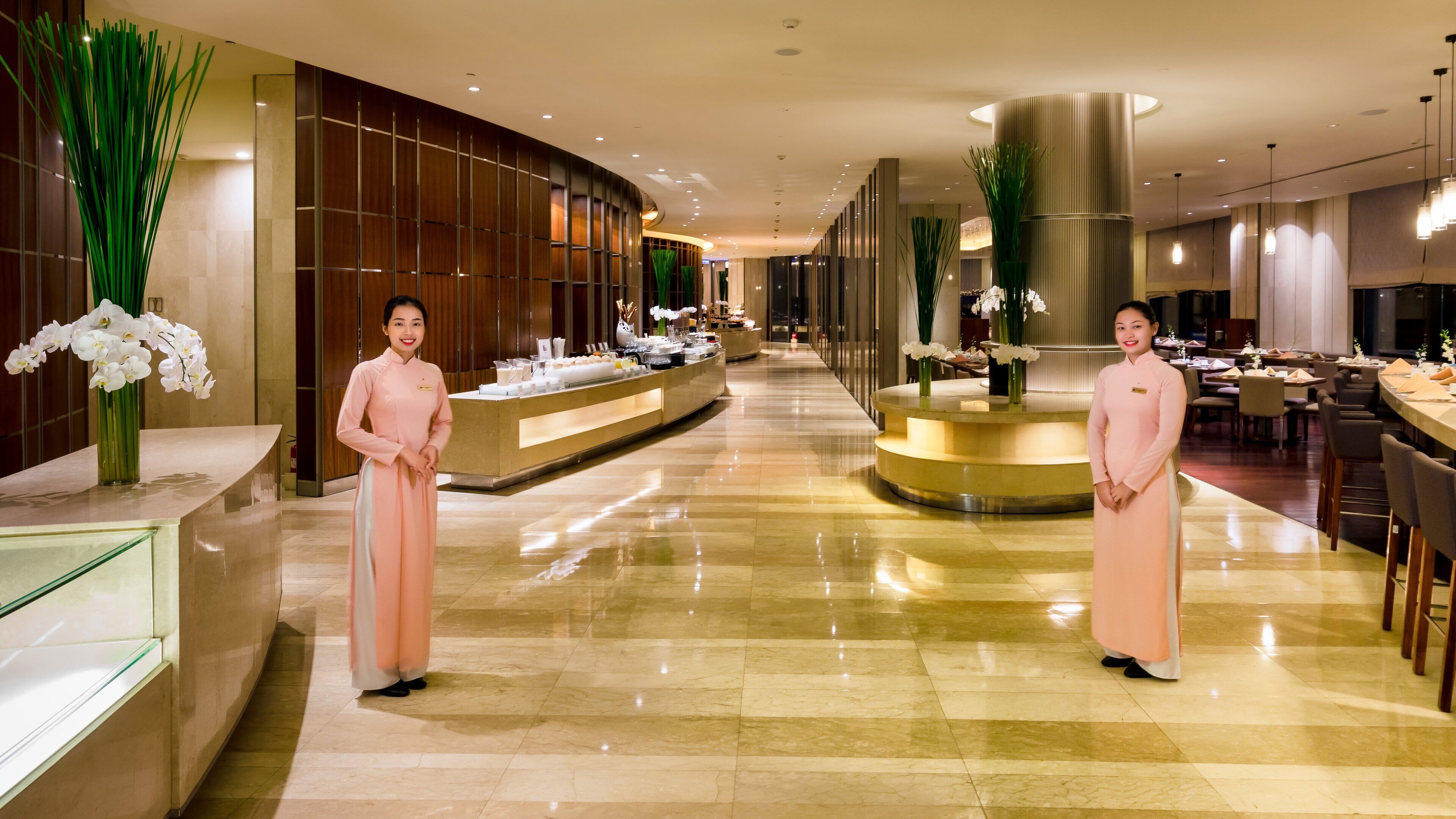 Eine großzügige Hotelhalle mit einem glänzenden Marmorboden, einer Rezeption und einer Sitzecke.