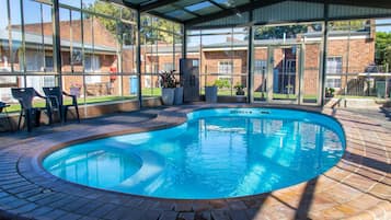 Una piscina techada, sillones reclinables de piscina