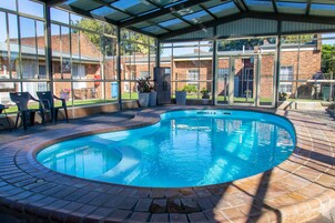 Una piscina techada, sillones reclinables de piscina