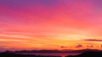 A sunset view over a lake with distant mountains.