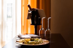 A dining table with a plate of food, two empty wine glasses, and a bottle of wine. - Hotel O Val Do Naseiro (Viveiro)