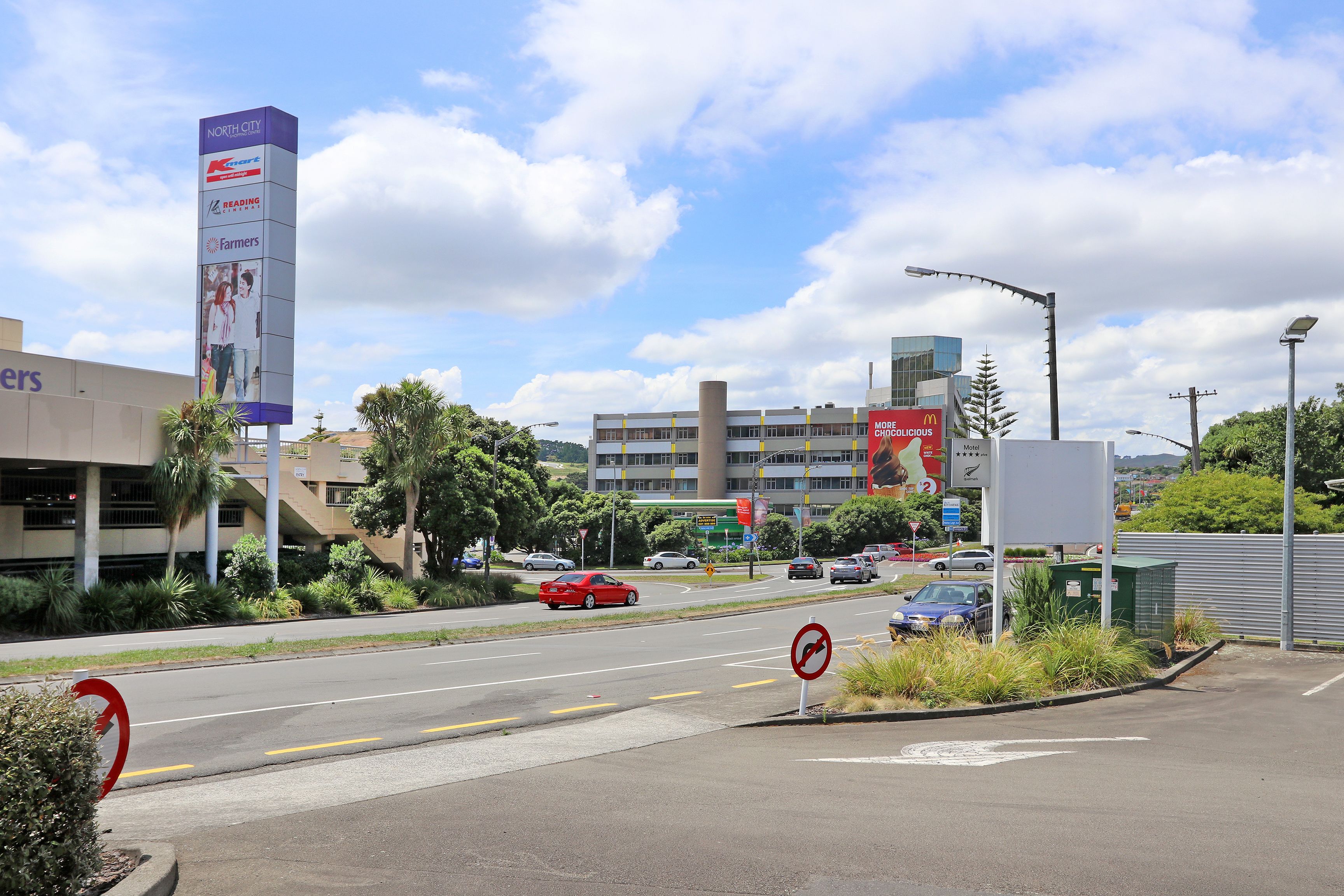 A multi-story building with a large billboard advertising a supermarket chain.